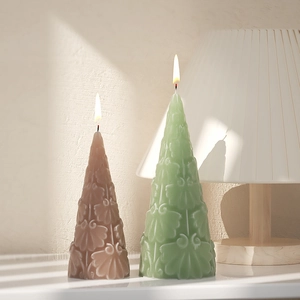 Detailed view of lit cone-shaped relief candles in pastel green and dusty rose