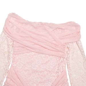 Detail of pink off-shoulder dress featuring pleated bodice and intricate lace sleeves