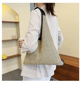 Detailed close-up of woven tote bag texture with black shoulder strap worn by model