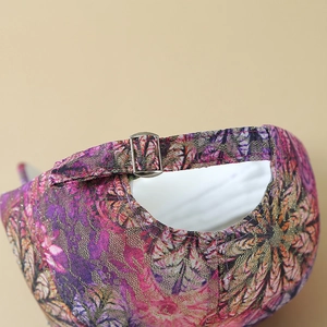 Detail of adjustable metal buckle and colorful floral pattern on a lace baseball cap