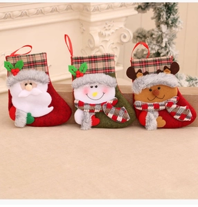 Three plush Christmas stockings with Santa, Snowman and Reindeer patterns on fireplace