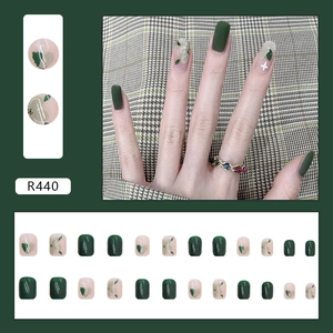 Unghie finte corte riutilizzabili con design verde scuro e motivi a stella astratti