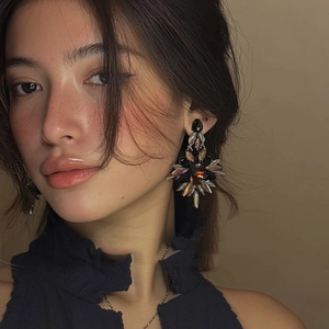 Gros plan de boucles d'oreilles vintage avec pierre noire et cristaux aux reflets irisés