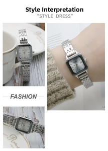 Detail of square silver quartz watch with stainless steel strap and roman numerals