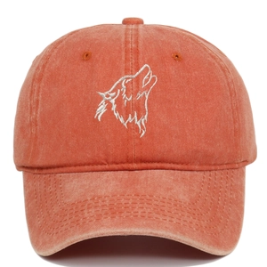 Detail of embroidered wolf head on vintage washed orange-red cotton baseball cap