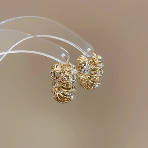 Macro shot of gold layered hoop earrings with pavé set sparkling crystals details