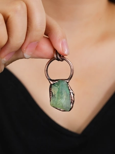 Vintage irregular raw fluorite crystal pendant wrapped in bronze wire held by a model