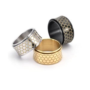 Macro detail of honeycomb engraved rotatable rings in silver, gold, and black steel