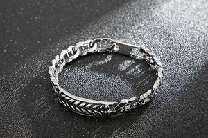 Close-up of vintage silver wheat chain bracelet with embossed clover patterns
