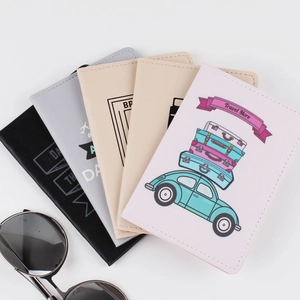 Flat lay of multiple PU leather passport covers with travel prints and sunglasses