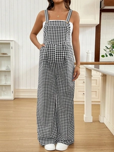 Detail of gingham maternity overalls with wide leg design in a cozy home kitchen setting