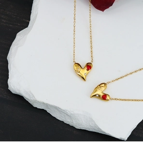 Détail du collier cœur en or 18 carats avec émail rouge et diamant blanc sur pierre