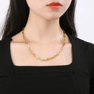Close-up of golden lip chain necklace on model showing delicate links and metallic luster