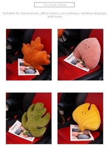 Detail of colorful leaf-shaped plush pillows with cute smiles on a red leather car seat
