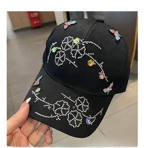 Detail of colorful rhinestones butterfly and flower patterns on black cotton baseball cap