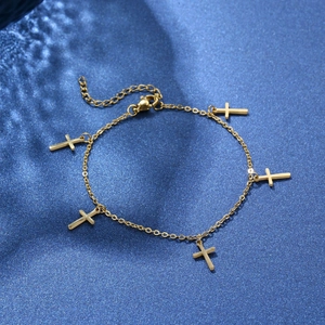 Golden stainless steel chain bracelet with five cross charms on navy blue fabric