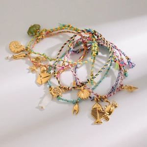 Detail of bohemian ocean charms with sea stars and conchs on braided rope bracelets