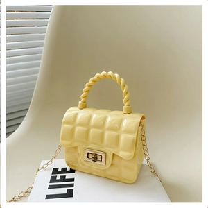 Detail of yellow quilted jelly bag with metal twist lock and gold chain strap