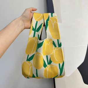 Detail of knitted tote bag with yellow tulips pattern and textured fabric handle
