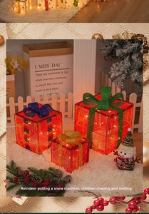 Detailed view of three red LED light-up Christmas gift boxes with festive glitter bows