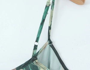 Détail de la boucle réglable sur la bretelle d'une robe verte à imprimé floral