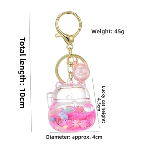 Detail of pink lucky cat liquid quicksand keychain with gold metal hook and beads
