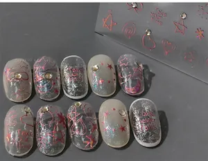 Macro detail of red laser Christmas nail stickers with rhinestones and star patterns