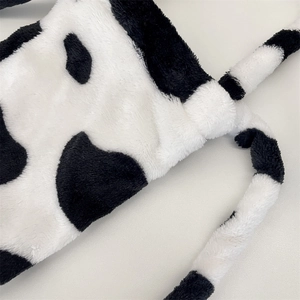 Detailed close-up of soft plush cow print fabric with shoulder straps for water bottle bag