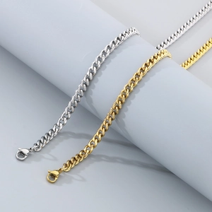Detailed close-up of gold and silver cuban link chains with square pendants on blue props