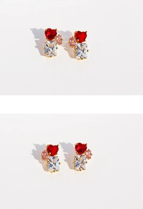 Macro detail of heart-shaped red zircon and emerald-cut stones in gold prong setting