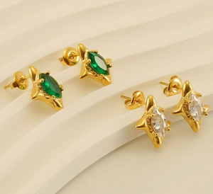 Detailed macro view of 18k gold plated starburst earrings with green and clear zircon stones