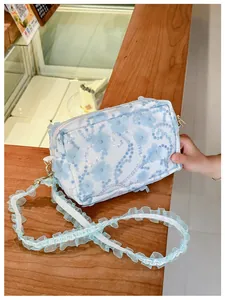 Detail of floral embroidery and shiny sequins on kids crossbody bag with lace strap
