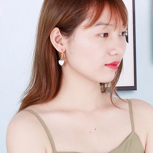 Boucles d'oreilles perles en cœur élégantes avec anneaux dorés torsadés sur mannequin