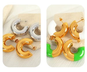 Detailed display of four pairs of C-shaped hoop earrings in gold, silver, white and green