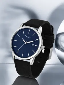 Detail view of TOMI minimalist watch with silver case, blue dial and date window