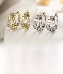 Close-up of pavé zircon geometric earrings in silver and light coffee gold finish