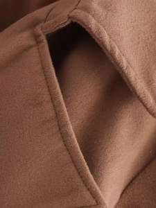 Vue macro détaillée des coutures et de la texture des poches du manteau en laine marron
