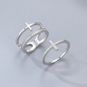 Macro detail of silver cross ring set with sparkling zircon stones and layered design