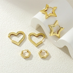 Close-up of gold geometric earrings set featuring star, heart and hexagon shaped hoops