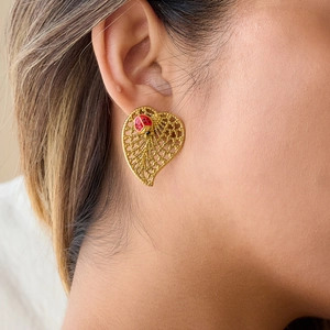 Golden heart hollow leaf earrings with ladybug detail on model for women fashion