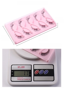 Detailed view of the false eyelash packaging dimensions and weight measurement on a scale