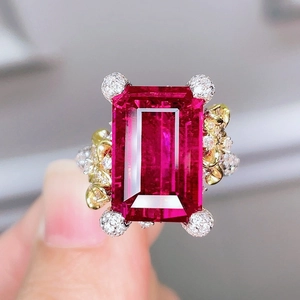Macro shot of rectangular red gemstone ring with intricate gold and silver floral detailing