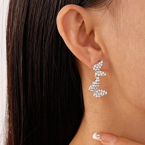 Detailed view of silver butterfly tassel earrings with sparkling rhinestones on model