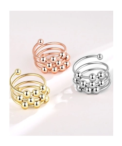 Close-up of triple-tone fidget rings with movable beads in gold, silver, and rose gold