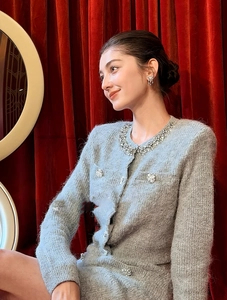 Detail of tweed cardigan with rhinestone collar and floral crystal buttons in luxury setting