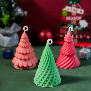 Three colorful spiral Christmas tree candles in pink, green, and red for festive decor