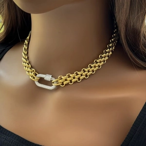 Close-up of gold chunky chain necklace with a large crystal-encrusted carabiner clasp