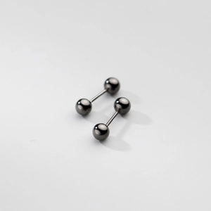 Gros plan de boucles d'oreilles barbell en argent s925 poli gris fusil sur fond blanc