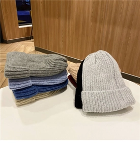 Dettaglio di berretti in maglia spessa multicolore in grigio, blu, beige e nero per l'inverno