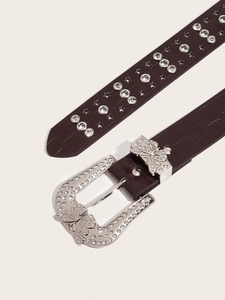 Detailed macro view of dark brown croc-pattern belt with silver butterfly rhinestone buckle